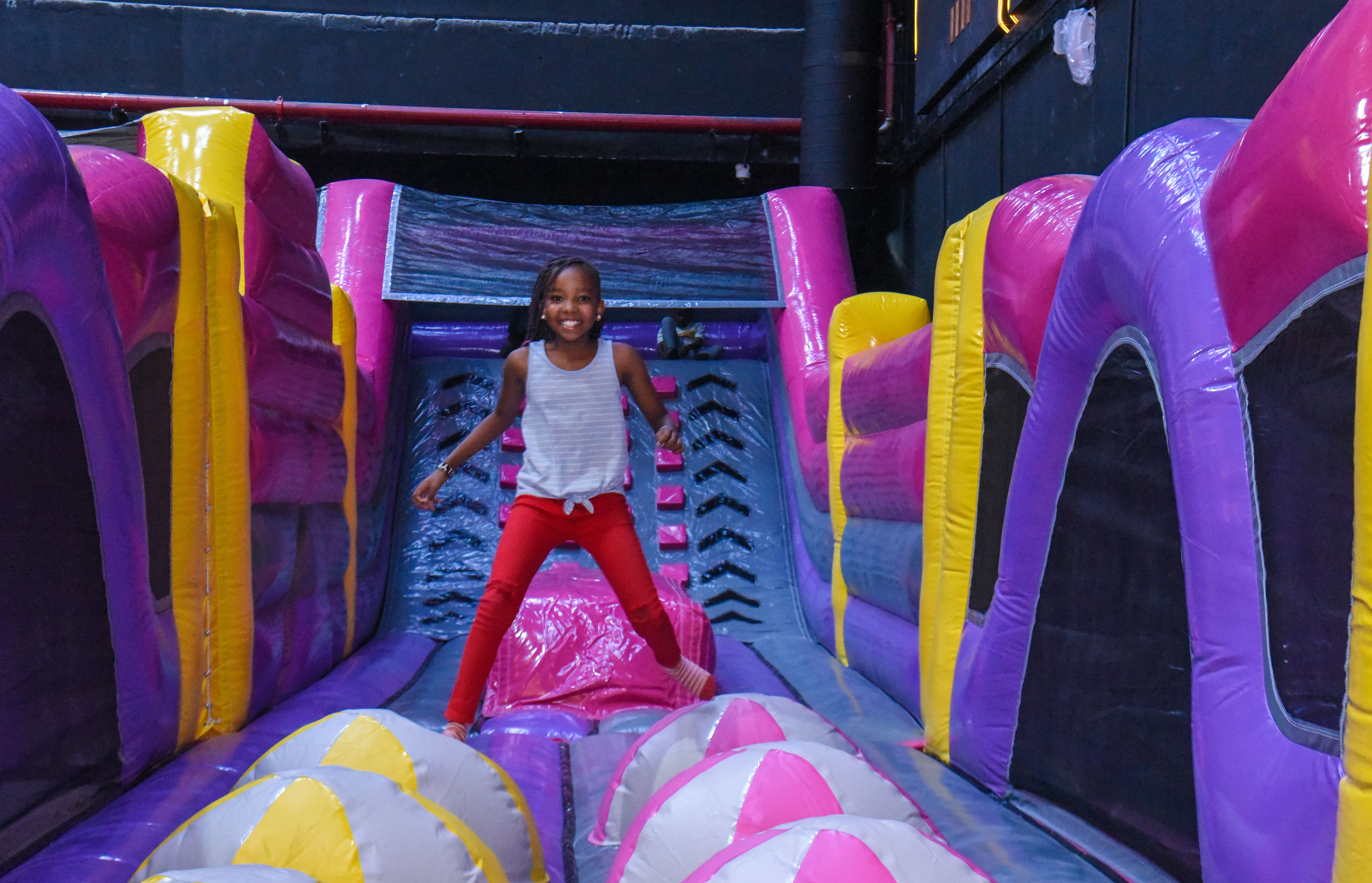 Guest landing on Bag Jump at The Hub Park, a bounce place and game center near me with fun zones for all.