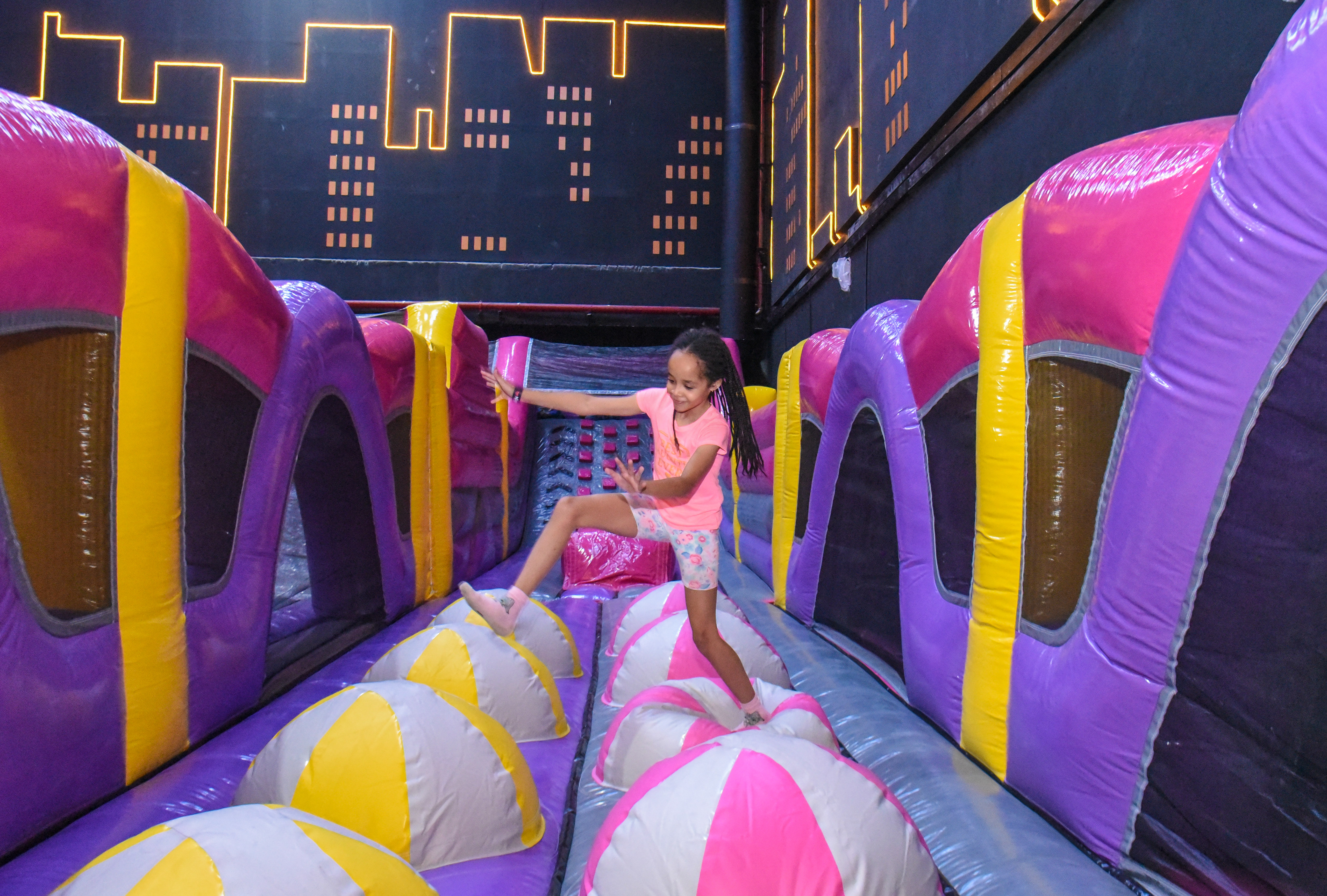 Guest landing on Bag Jump at The Hub Park, a bounce place and game center near me with fun zones for all.