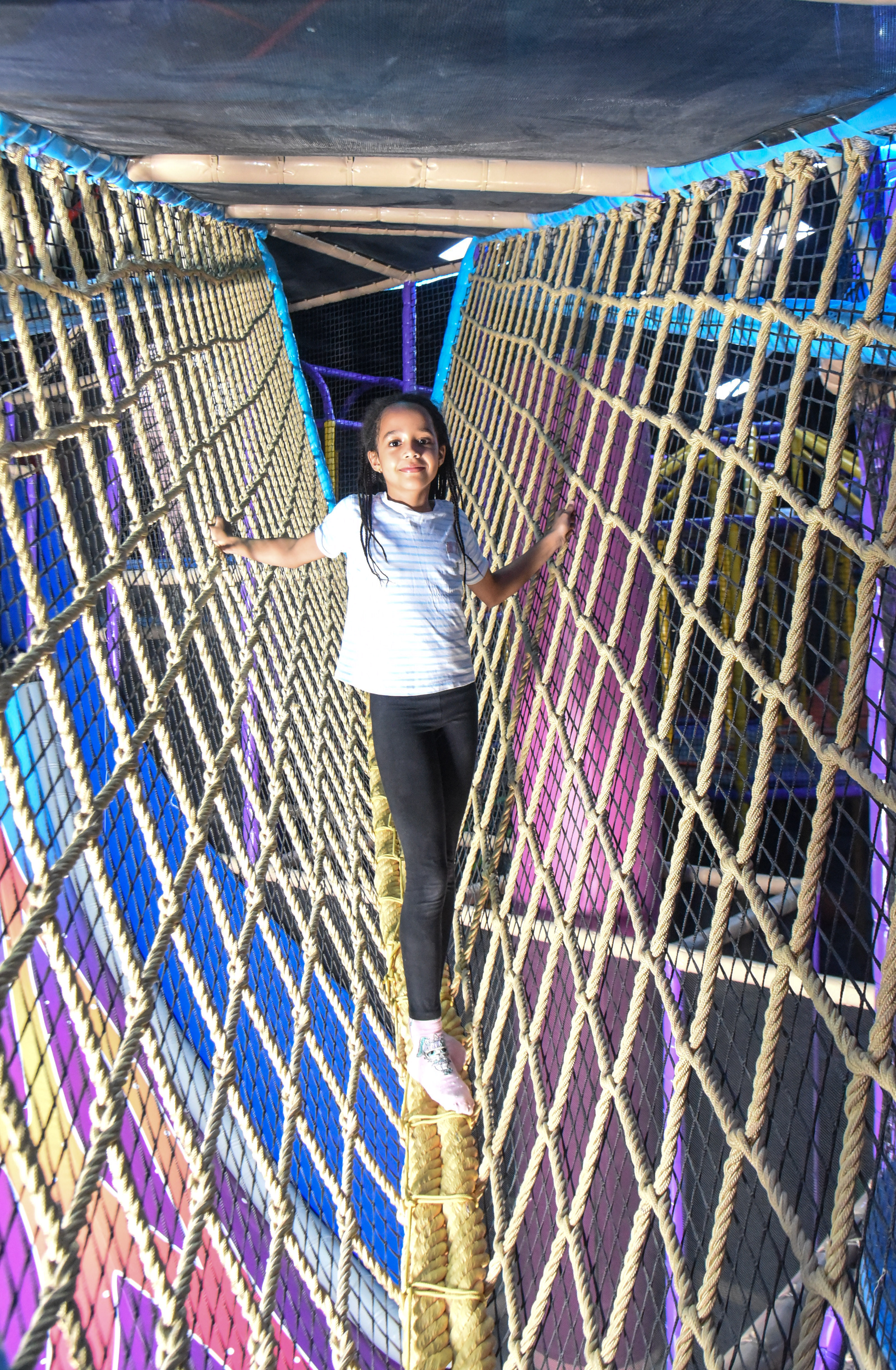 Child balancing in the net maze challenge at The Hub Park, a thrilling indoor fun zone and bounce place.