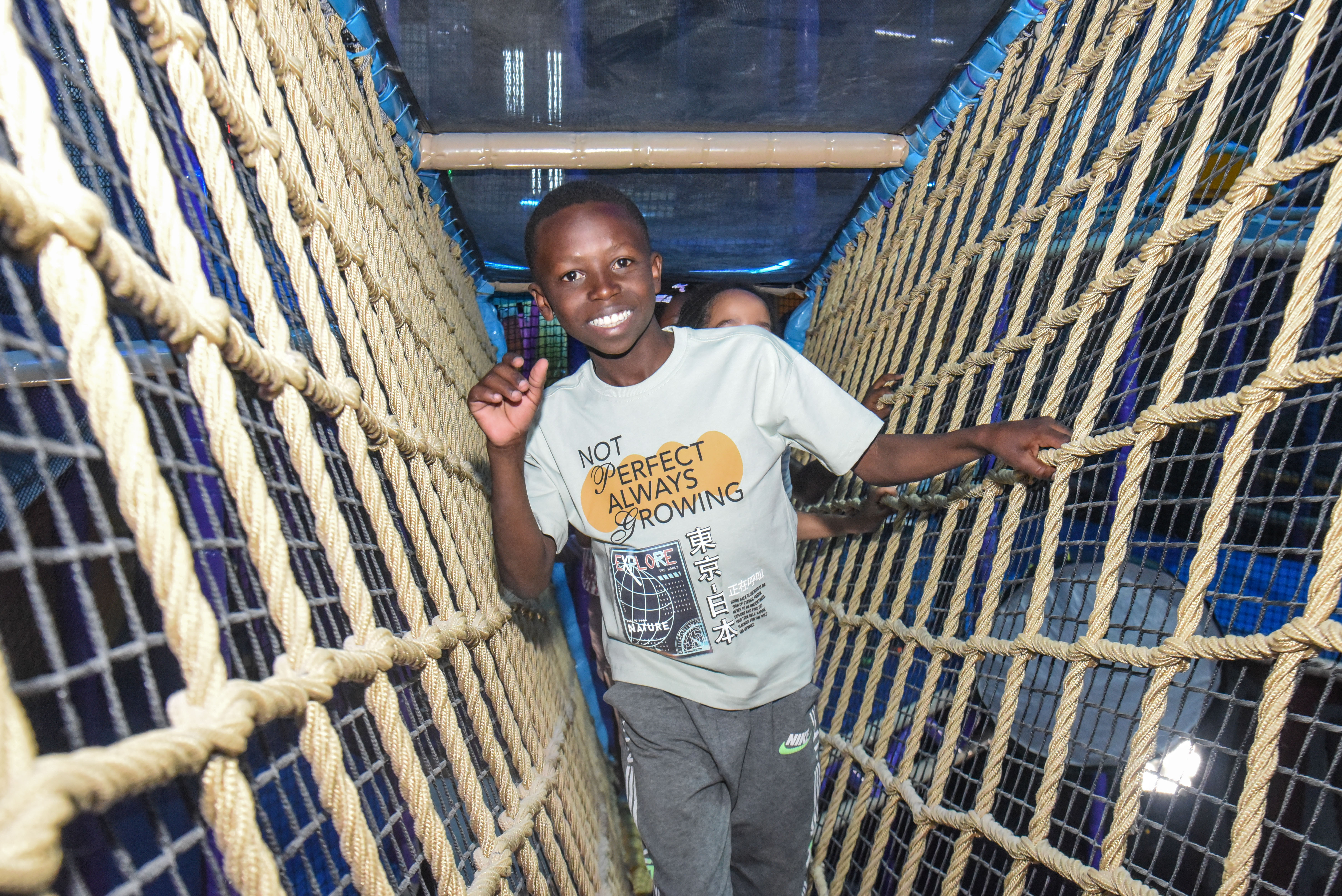 Child balancing in the net maze challenge at The Hub Park, a thrilling indoor fun zone and bounce place.