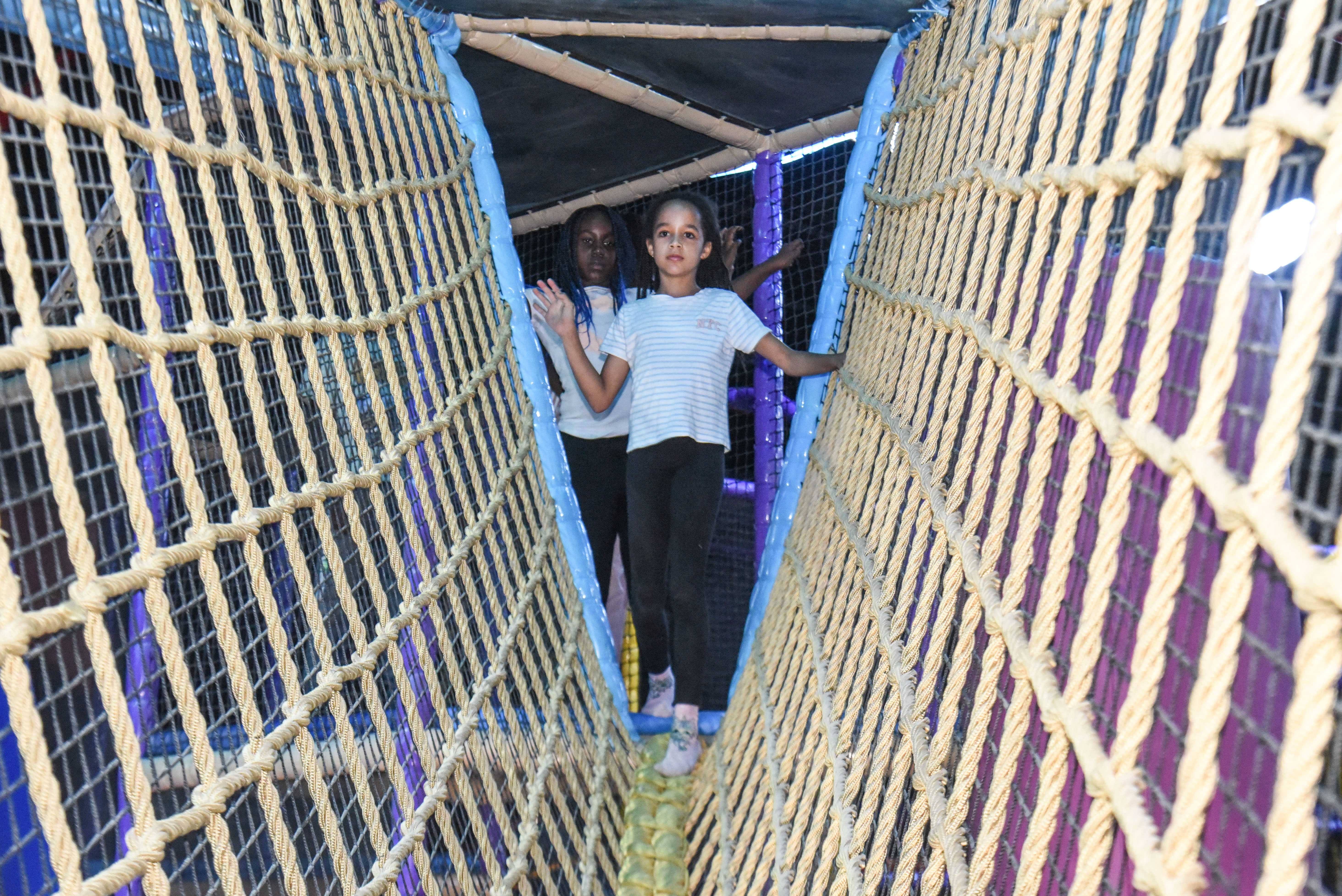 Child balancing in the net maze challenge at The Hub Park, a thrilling indoor fun zone and bounce place.