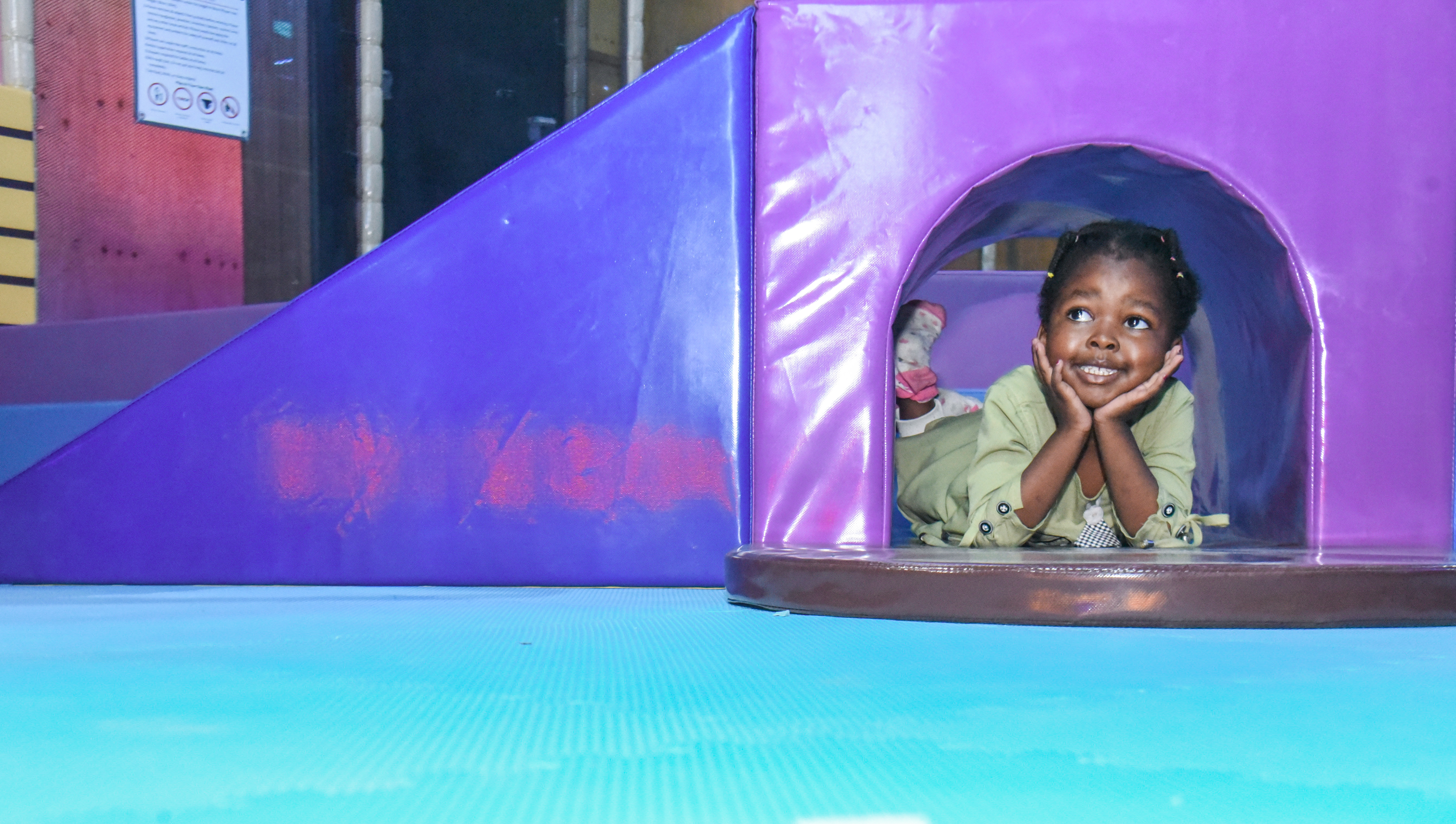 Smiling toddler enjoying safe and fun activities at The Hub Park, a happy family fun center and indoor play arena.