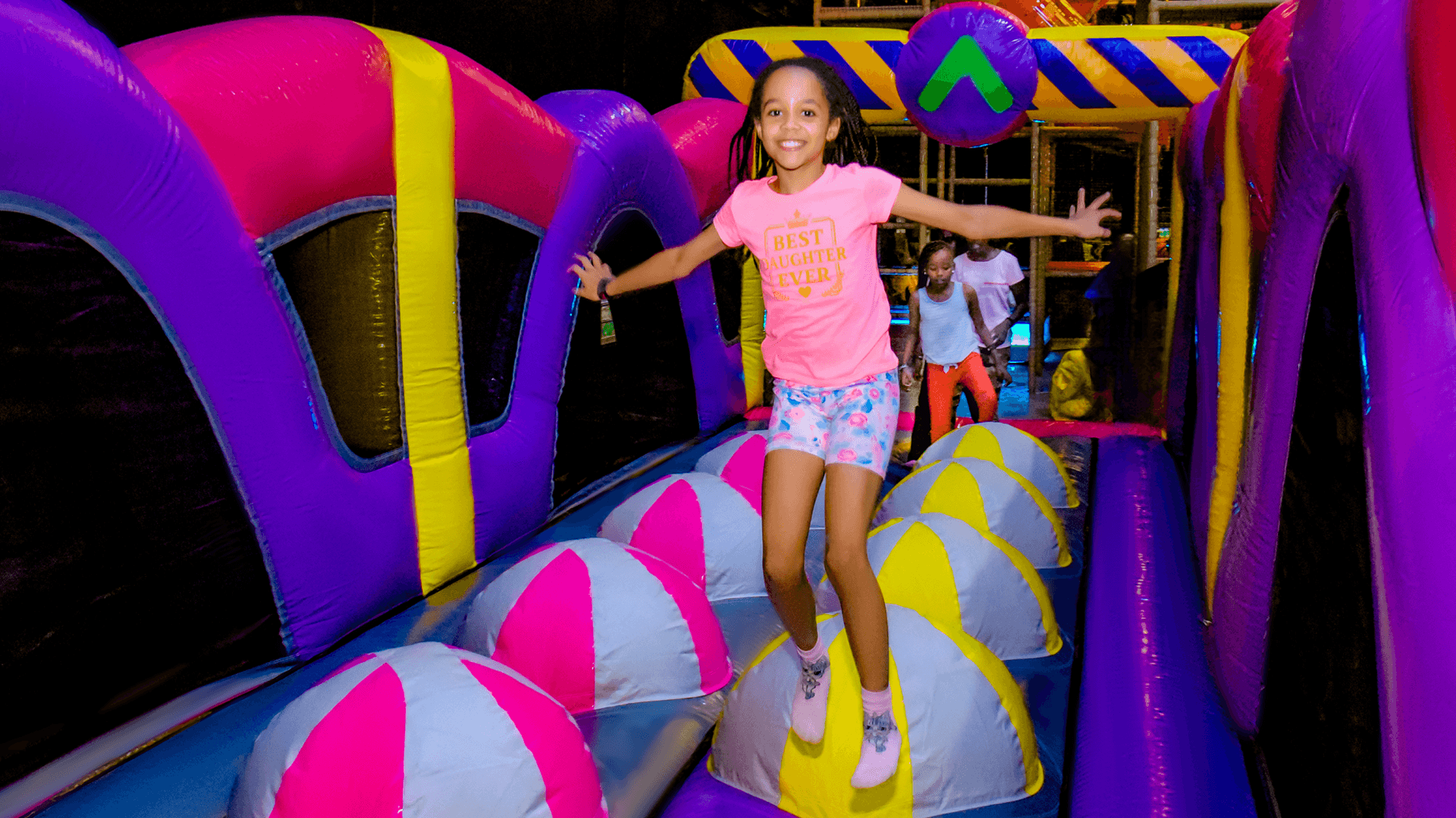 Girl joyfully jumping on an inflatable at The Hub Park, a bounce bounce indoor fun center and family park near Nairobi.