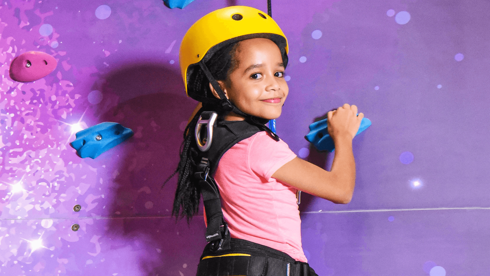 Adventurer scaling the climbing wall at The Hub Park, a fun center near me for families in Nairobi.